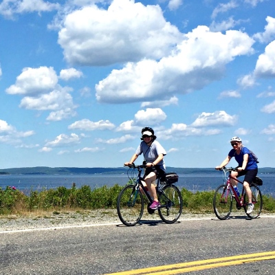 Two cyclists bike along the coast